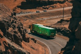 Green truck between rocks of desert landscape
